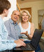 Happy aged couple talking with employee with laptop, фото № 6247698, снято 28 мая 2014 г. (c) Яков Филимонов / Фотобанк Лори