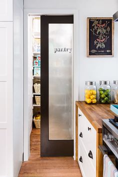 A frosted-glass pocket door closes off this pantry without obstructing floor space. And scraps of butcher block along the sides of the range-wall cabinets create a waterfall effect. | Photo: Andrea Rugg | thisoldhouse.com