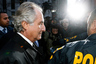 Disgraced financier Bernard Madoff is escorted by police and photographed by the media as he departs U.S. Federal Court after a hearing in New York, January 5, 2009