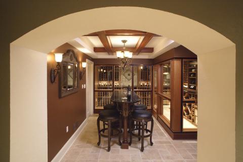 Mediterranean Wine Cellar with elegant wood framed wall mount mirror with crown detail