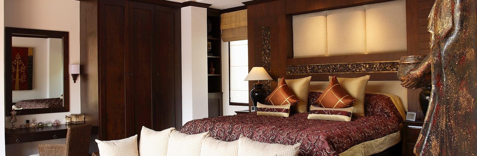 Asian Bedroom with large dark cherry wood ceiling beams