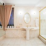 Fancy shower with glass door and golden frame