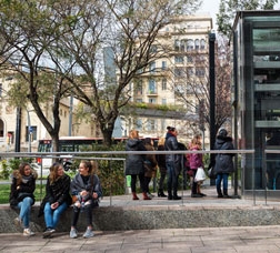 Un grup de noies assegudes a l’entrada d’una estació de metro