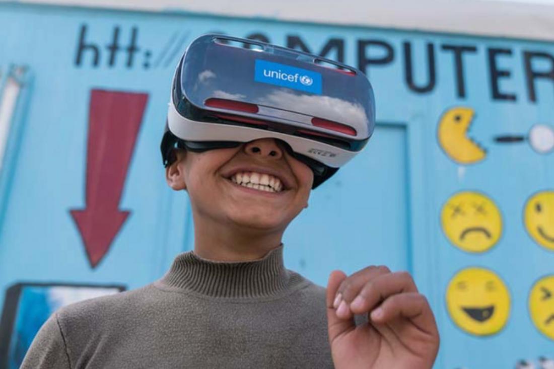 Mansoor, 12, watches the virtual reality documentary ‘Clouds over Sidra’ with a big grin, outside a UNICEF-supported Makani centre in the Za’atari camp for Syrian refugees. Photo: UNICEF/Herwig