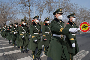 Armed police officers walk on a pedestrian crossing in Beijing on March 9, 2020, wearing masks amid the spread of the new coronavirus. (Photo by Kyodo News via Getty Images)