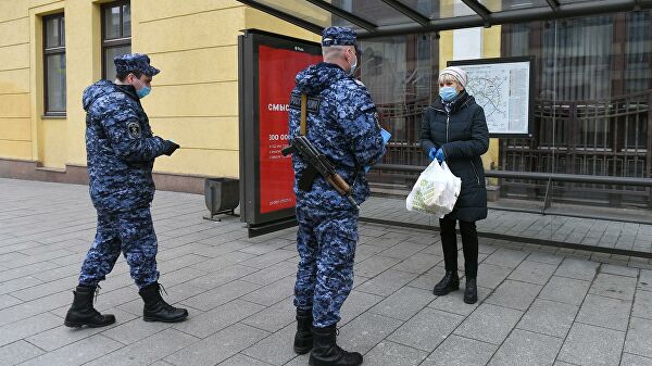 Сотрудники Росгвардии проверяют цифровой пропуск у женщины в Москве