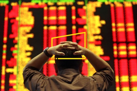 An investor reacts as he monitors the share index in a stock market gallery