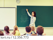 Купить «school kids and teacher writing on chalkboard», фото № 12356773, снято 15 ноября 2014 г. (c) Syda Productions / Фотобанк Лори