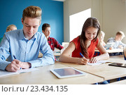 Купить «group of students with books writing school test», фото № 23434135, снято 22 апреля 2016 г. (c) Syda Productions / Фотобанк Лори