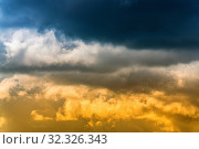 Купить «Dramatic blue thunderclouds on top and yellow-golden fluffy clouds illuminated by rays of sun on below. Stunning view natural meteorology background. Amazing cloudscape to weather change before rain.», фото № 32326343, снято 1 сентября 2019 г. (c) А. А. Пирагис / Фотобанк Лори