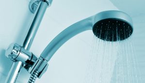 closeup of a height-adjustable shower head pouring water