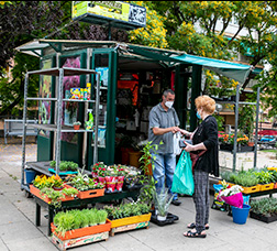 Una dona amb mascareta compra plantes en un quiosc 