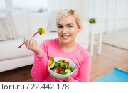 smiling young woman eating salad at home. Стоковое фото, фотограф Syda Productions / Фотобанк Лори