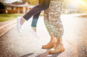 Young military couple kissing each other, homecoming concept, wa