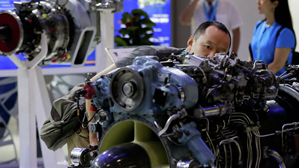 Мужчина рассматривает двигатель вертолета, разработанный компанией Мотор Сич, представленный на выставке Aviation Expo China в Пекине