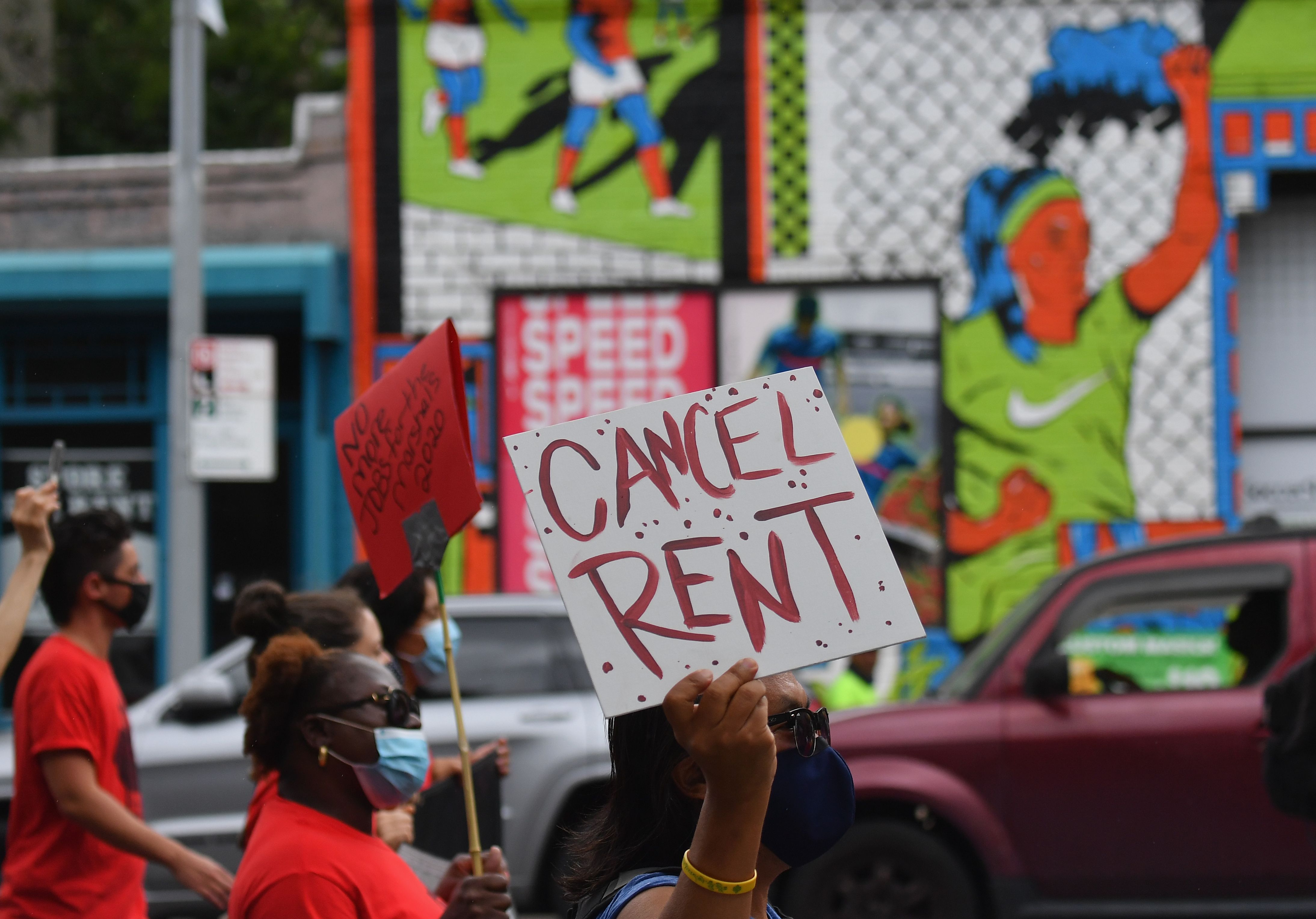 A protester holds up a sign that reads, “Cancel rent.”