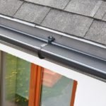 Plastic guard over new dark grey plastic rain gutter