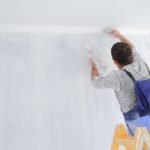 Men painting empty home interior