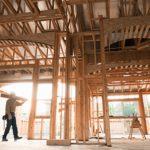 Builder carrying wood plank