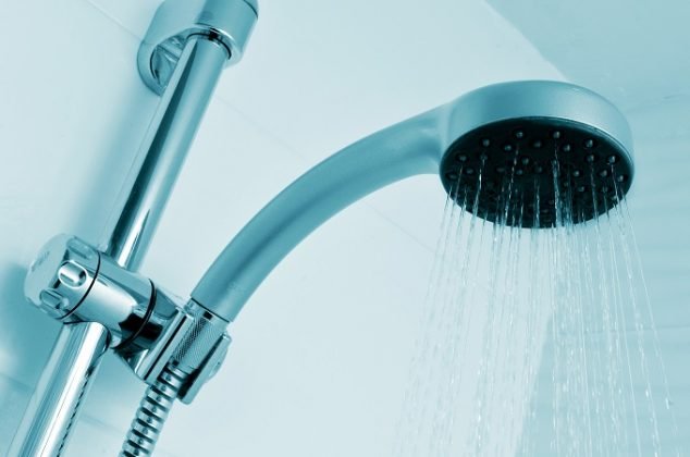 closeup of a height-adjustable shower head pouring water