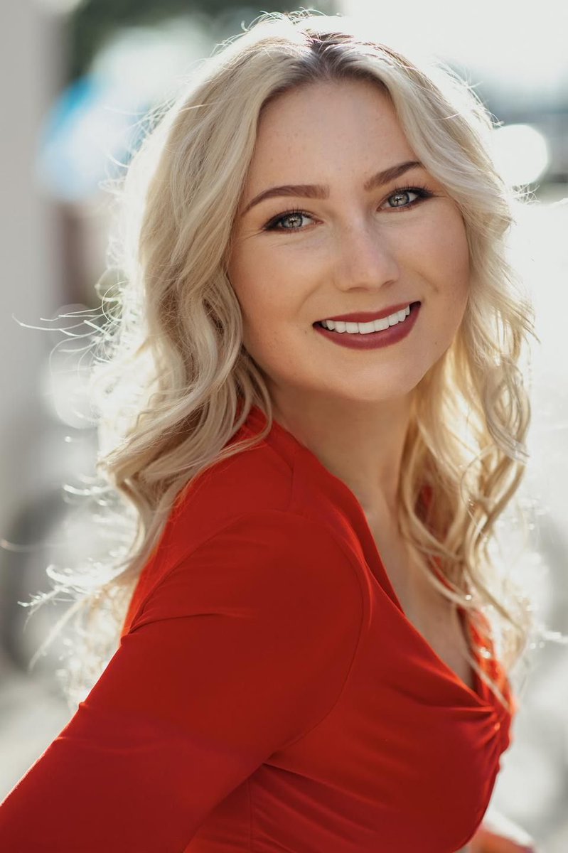 IMAGE DESCRIPTION:  Portrait of Keely Cat-Well a Caucasian woman with blonde hair wearing a bright red top.