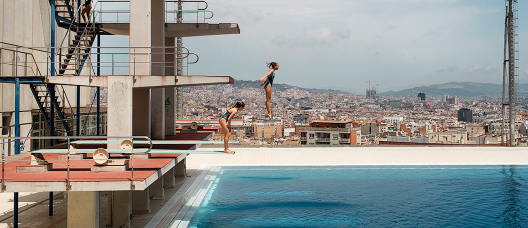 Dues noies salten d'un trampolí a les piscines Picornell