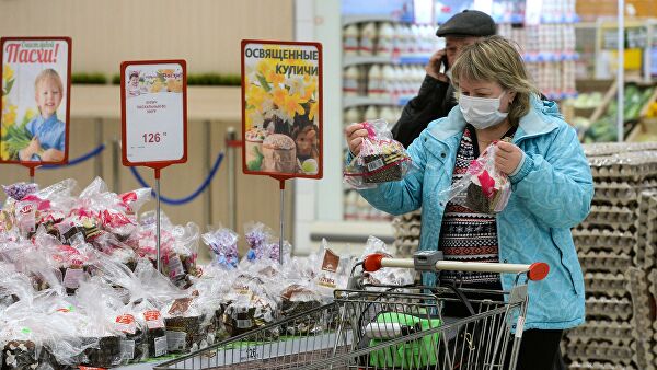 Женщина выбирает пасхальные куличи в суперрмаркете