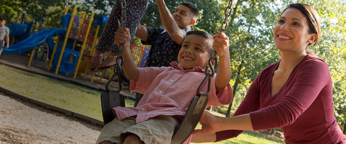 Desktop Image for Male Military Spouse pushing child on swing with military wife