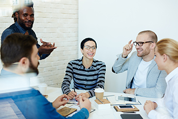 group collaborating, smiling and laughing at a table 