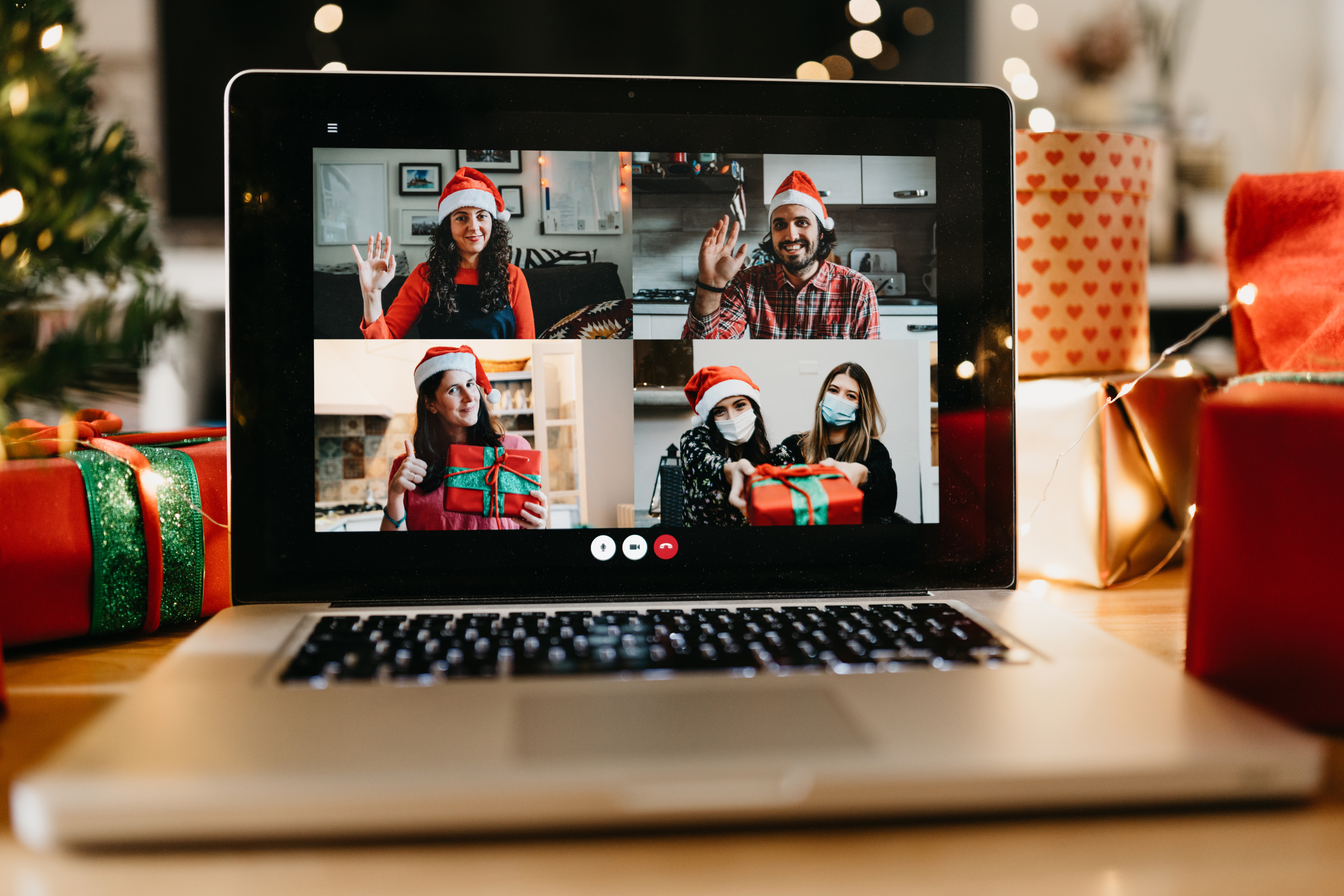 Video call of a laptop screen showing five people dressed in holiday wear.