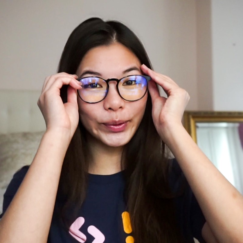 A young woman puts her glasses on 