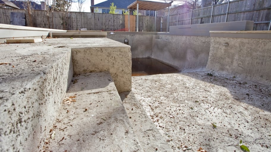 empty swimming pool enclosed by fence