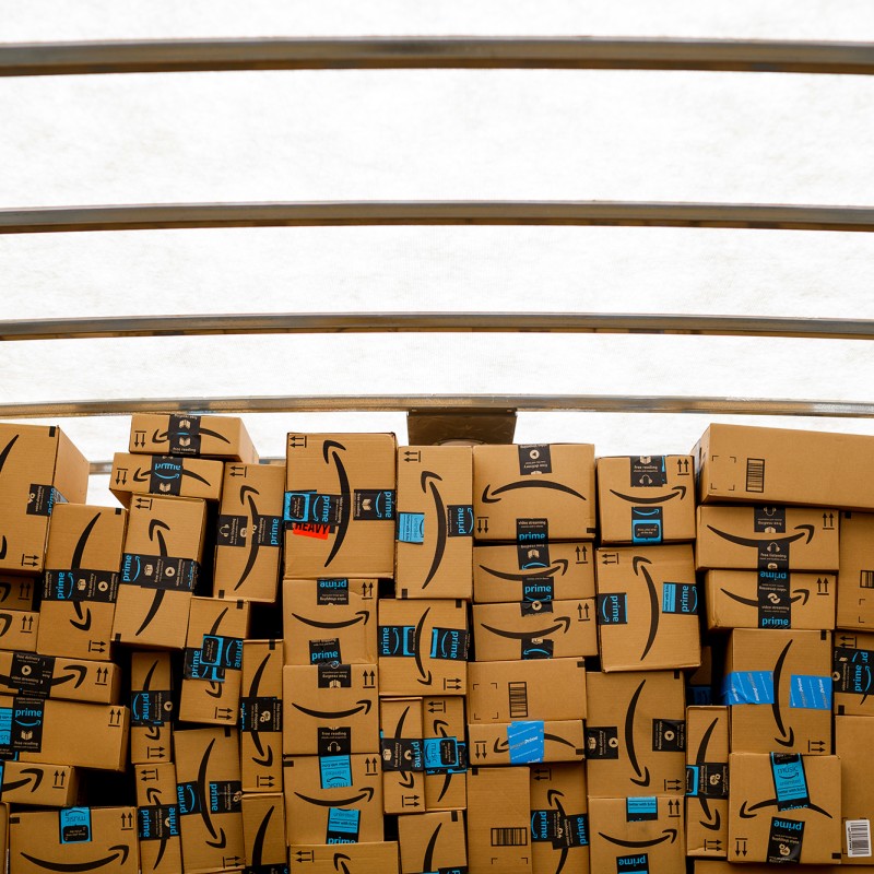 Amazon boxes stacked in a well-lit space inside a truck.