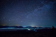 Starry night sky over the mountain city in the fog