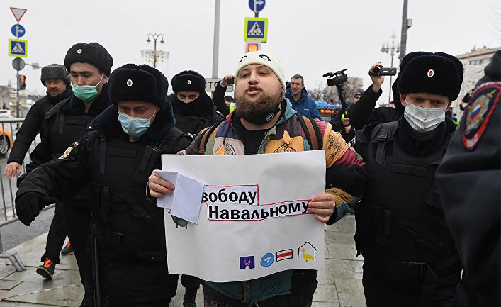 Сотрудники правоохранительных органов задерживают участника несанкционированной акции сторонников Алексея Навального в Москве