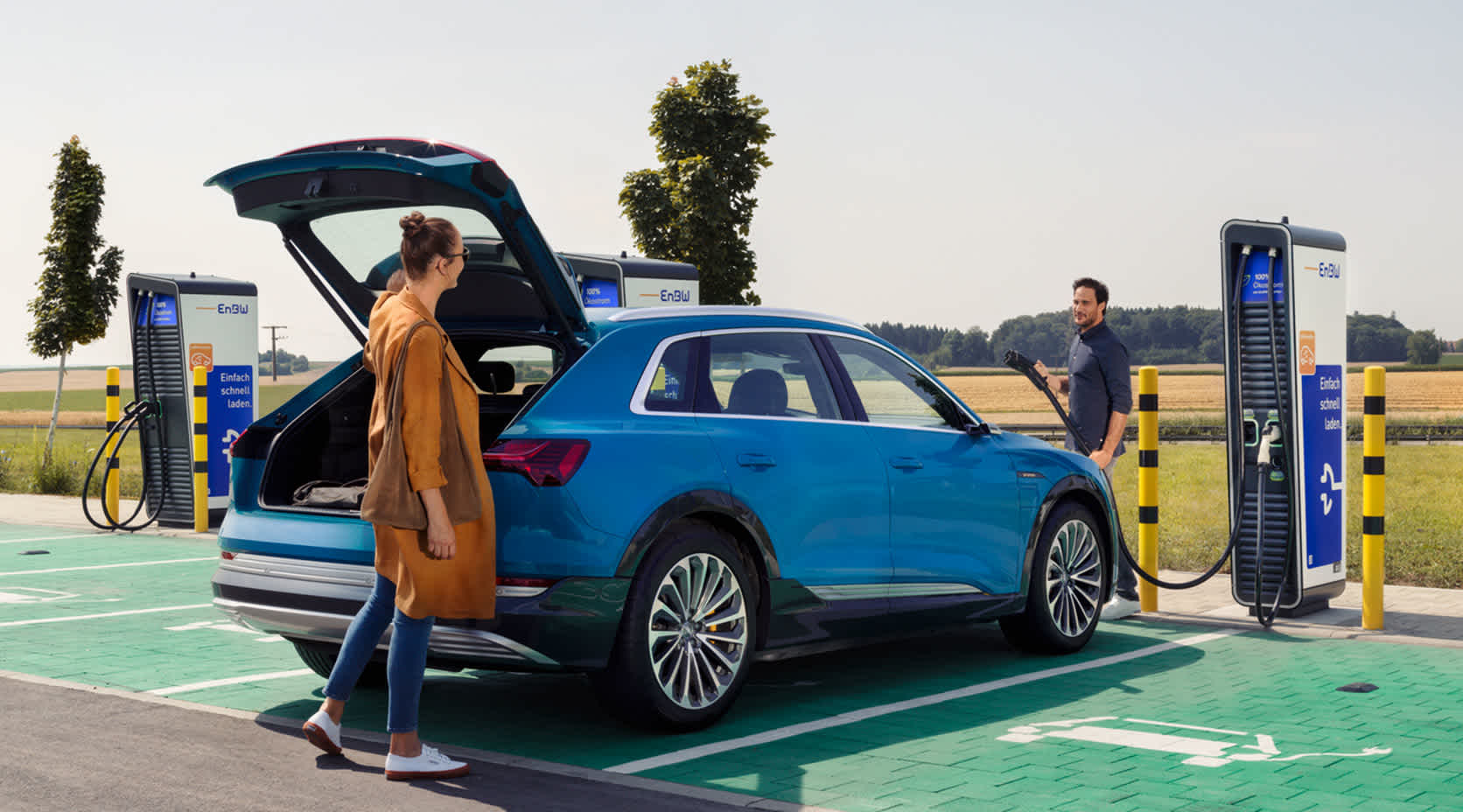 Pärchen am Parkplatz beim Laden eines E-Autos