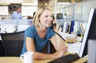 Modern office with woman using the phone and a computer.