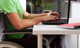 Disabled man writing on laptop