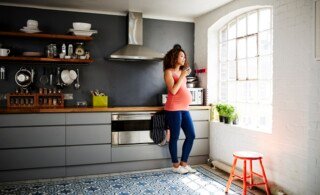 Pregnant woman in tidy modern kitchen in a renovated old building