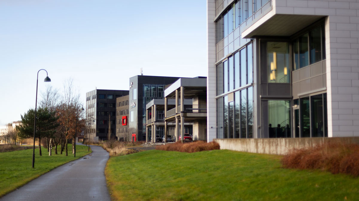 A wide bike and pedestrian path that runs alongside office buildings.