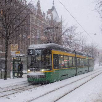 Un tranvía circula por una calle completamente cubierta de nieve.