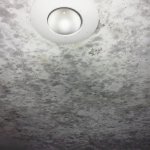 a ceiling covered with splattered patches of black mold 