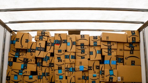 Amazon boxes stacked in a well-lit space inside a truck.