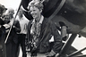 Amelia Earhart (1898-1937), American aviator, smiling as she stands near her plane.