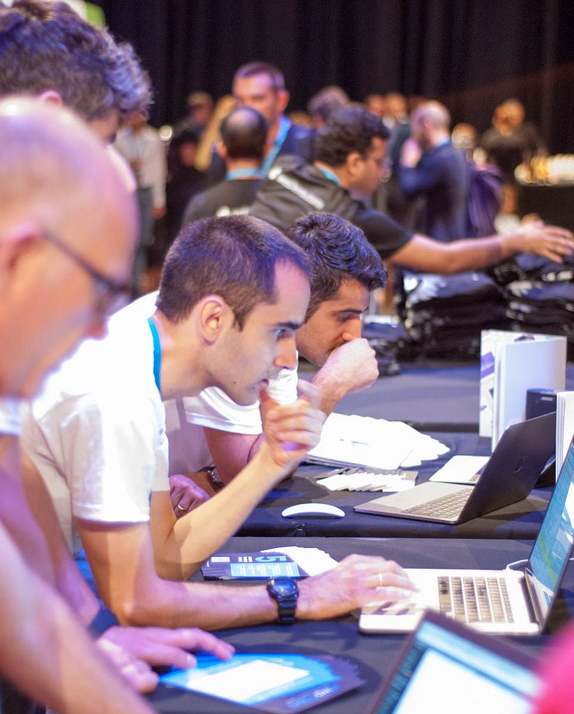 Three contributors working on computers at Contributor Day, WordCamp Europe