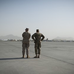 Generals John Allen and David Petraeus stand at an airfield in Afghanistan