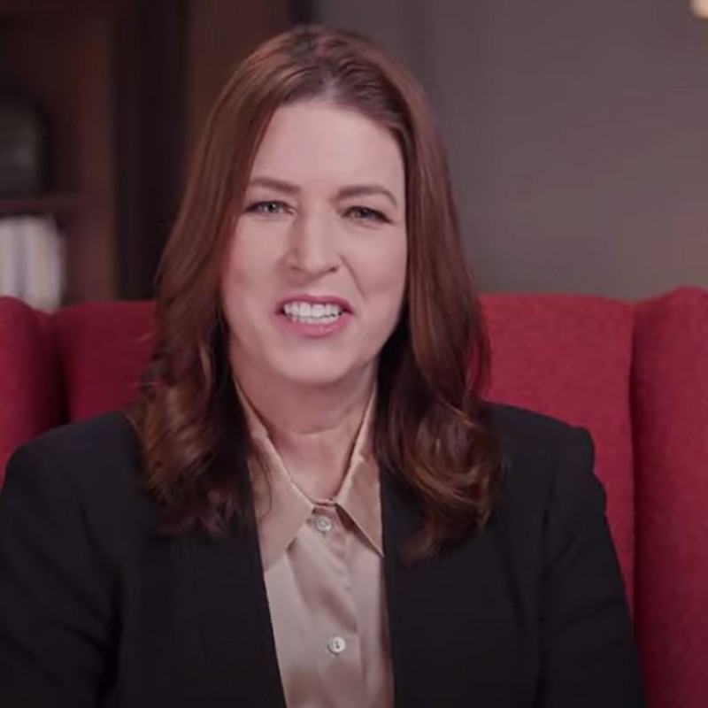 Amazon Sustainability Vice President Kara Hurst sits in an office setting in a red wingback chair. 