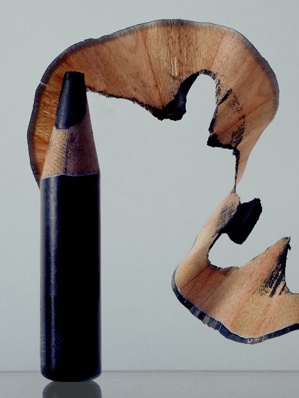 A black eyeliner pencil sharpened down to the bottom with pencil shavings.