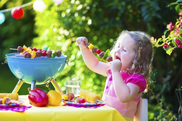 Little girl at a garden grill party.