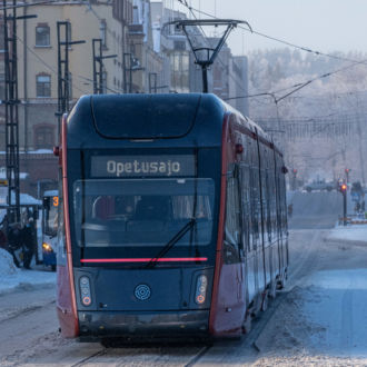 Un tranvía desciende por una calle cubierta de nieve.